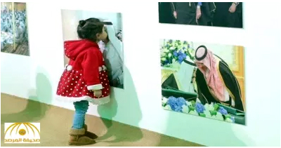 طفلة تطبع قبلة على صورة للملك سلمان في عفوية تامة - صورة
