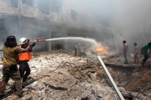 Civil defence members try to put out a fire at a market hit by air strikes in Idlib city, Syria June 12, 2016. REUTERS/Ammar Abdullah