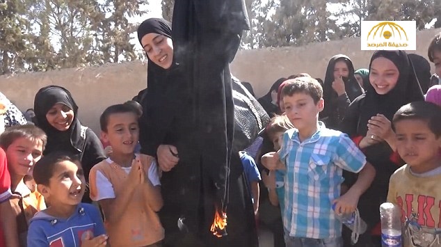 بالفيديو والصور: امرأة سورية تحرق نقابها احتفالا بتحرير مدينتها من قبضة داعش