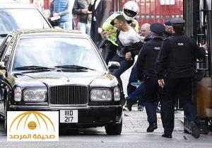 FILE- In this Wednesday, Oct. 26, 2016, file photo, police grab protestors that try to attack the car carrying the King of Bahrain, Hamad bin Isa Al Khalifa as he arrives at Downing Street in London. A pro-democracy activist says his wife was beaten and arrested in Bahrain after he jumped on a car carrying the island’s king during his recent visit to London. (AP Photo/Kirsty Wigglesworth, File)