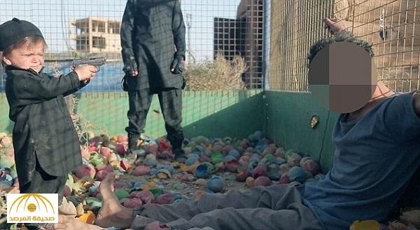 وسط كرات بلاستيكية ملونة ..  بالصور: "داعش" يدفع طفل لقتل سجين برصاص مسدس