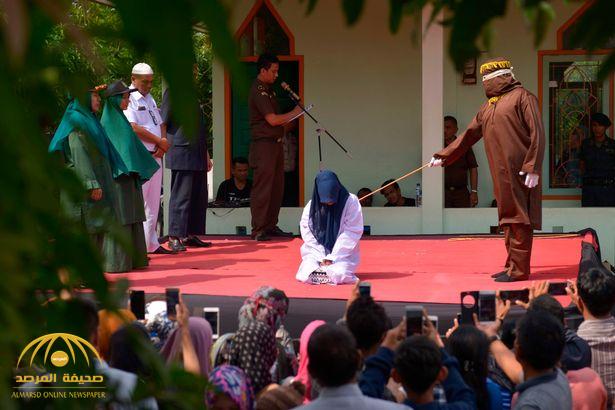 مقنعون ينفذون  عقوبة  "الجلد" في امرأة زانية بمقاطعة إندونيسية - صور وفيديو