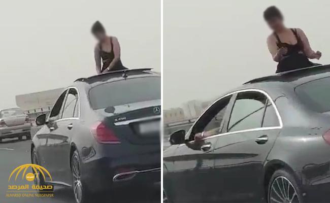 شاهد .. فتاة تتمايل وهي تطل من فتحة سيارة برفقة شاب على جسر ستره بالبحرين