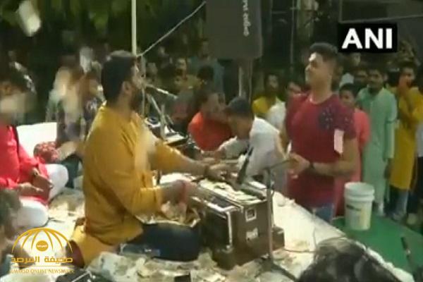 شاهد: إغراق منشد ديني بالنقود في حفل بالهند!