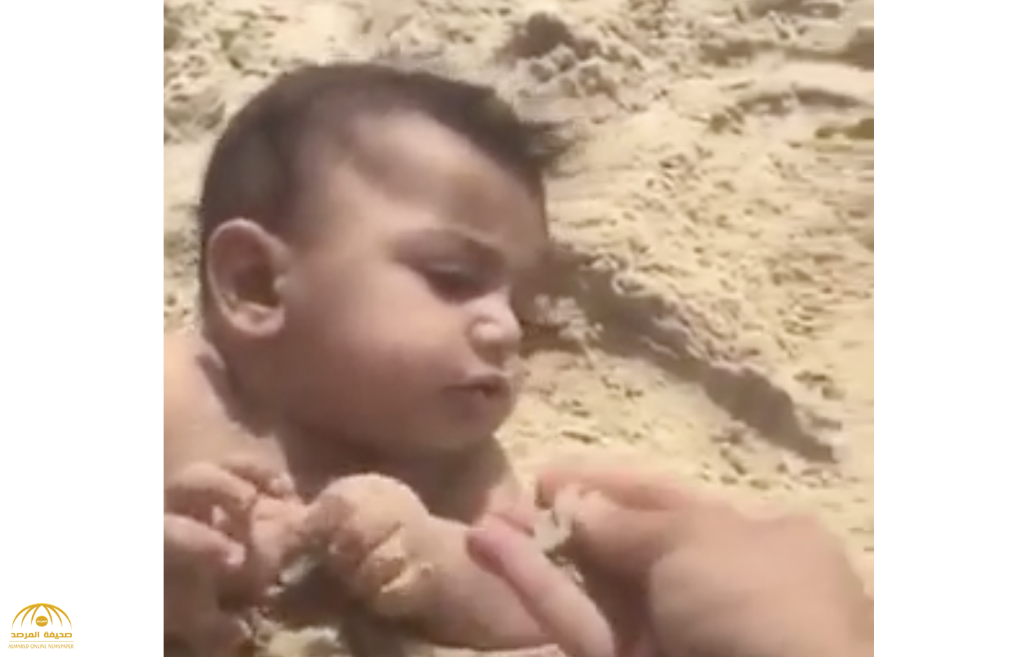 شاهد فيديو صادم.. شخص يدفن طفل في الرمل ويلقمه «التراب»