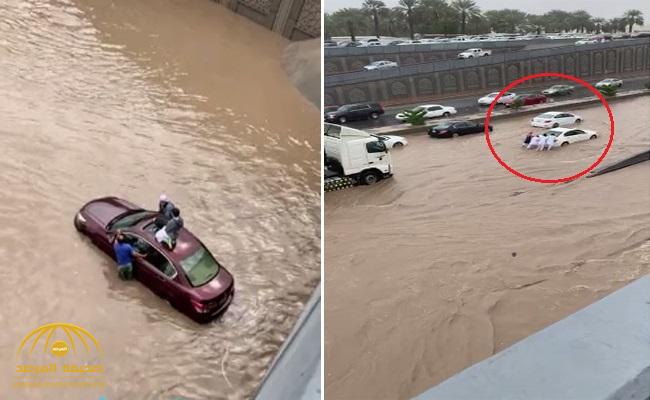 شاهد .. السيول تغمر أنفاق الدائري الثاني بالمدينة وطالبين يصعدان على سطح سيارة  للنجاة من الغرق