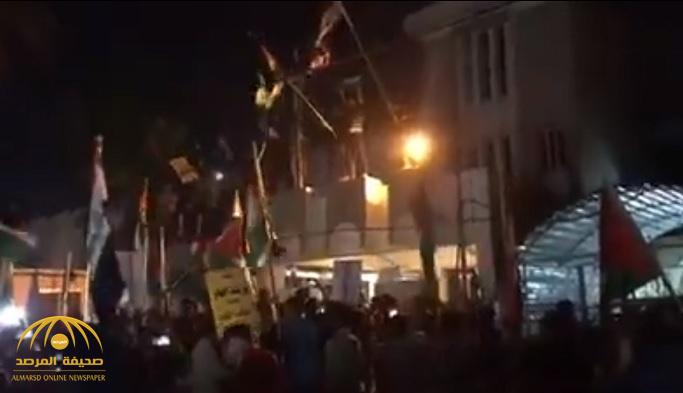 شاهد .. متظاهرون يقتحمون سفارة البحرين في بغداد وينزلون العلم
