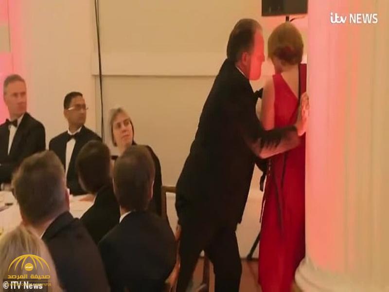 شاهد.. تصرف غريب من وزير بريطاني تجاه امرأة مرت بجوار الطاولة التي يجلس عليها!