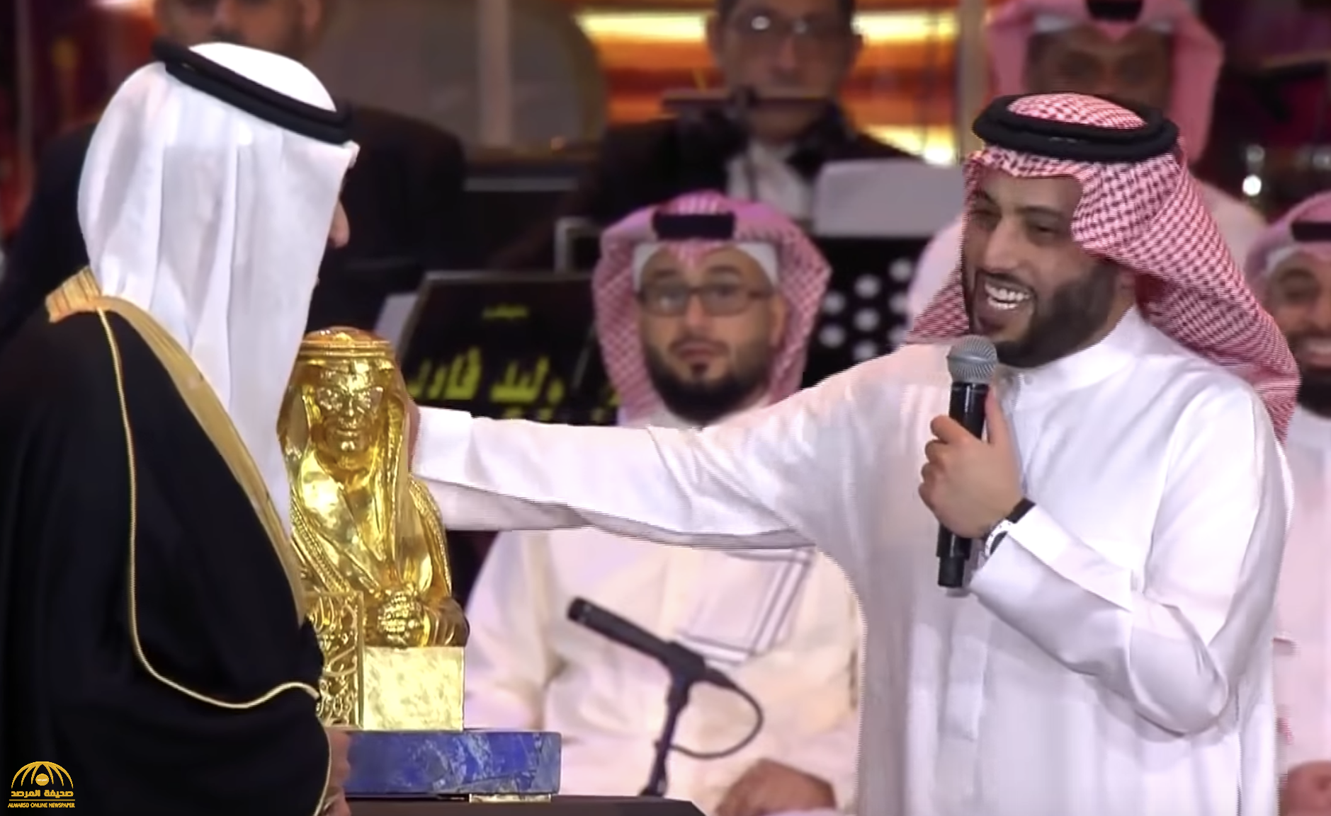 شاهد: "آل الشيخ" يفاجئ الأمير "بدر بن عبدالمحسن" بهدية تمثال له من الذهب الخالص