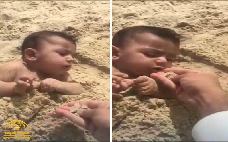 شاهد : فيديو صادم لشخص يدفن رضيعه ويطعمه من الرمال!