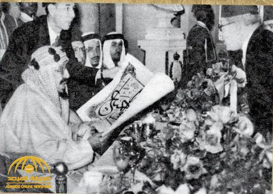 صورة نادرة للملك عبد العزيز يحمل لوحة كُتب عليها آية قرآنية.. والكشف عن مناسبتها