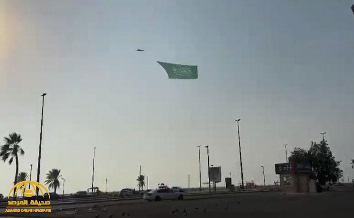 شاهد.. مروحية تحلق بـ"علم السعودية" على مسافة قريبة من سطح البحر في جدة!