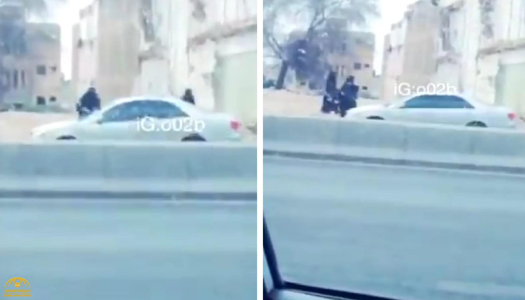 شاهد: امرأتان تعتديان بالحجارة على سيارة متوقفة بجانب طريق عام