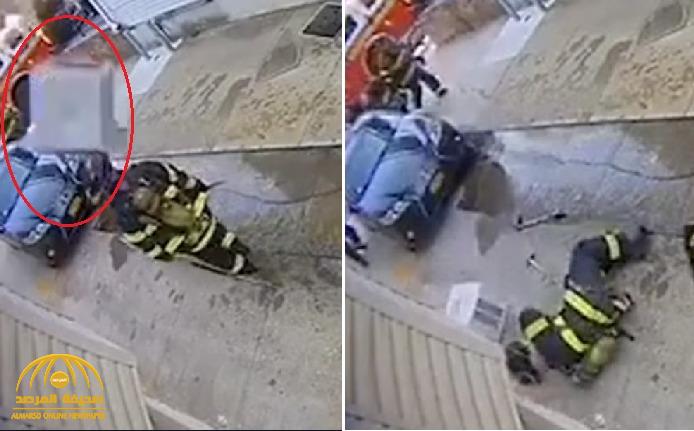 شاهد..  سقوط "مكيف" على رأس رجل إطفاء أثناء سيره بالشارع!