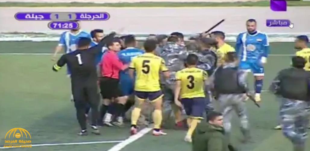 شاهد: مشجع يقتحم ملعب أثناء المباراة ويعتدي على الحكم.. وردة فعل مفاجئة من الأخير!