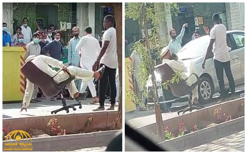 شاهد.. مقيم في حالة غير طبيعية يجلس على كرسي وسط الشارع في الرياض  ويصفع شخص وقف أمامه