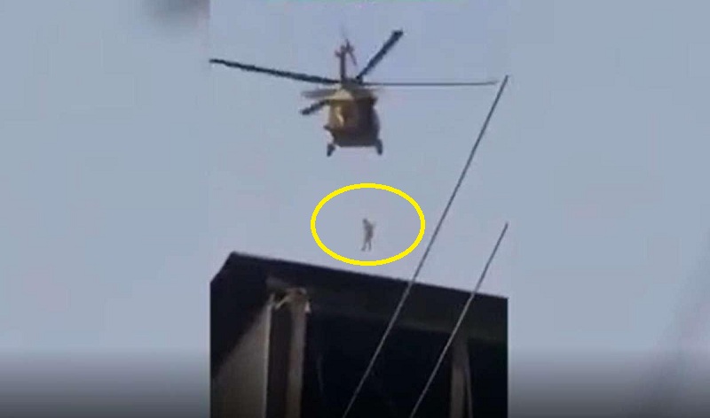 شاهد.. "طالبان" تحلق بطائرة "هليكوبتر" في سماء قندهار وفي أسفلها شخص معلق في الهواء