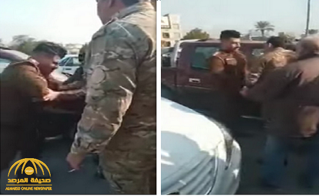 شاهد: ضابط عراقي يشهر سلاحه على  بائع بسطة ويعتدي عليه وسط عدد من المتجمهرين في بغداد